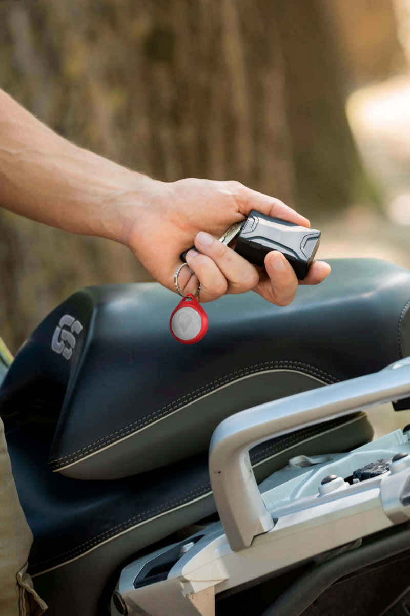 foto motociclista davanti alla sua moto mentre posiziona l'antifurto GPS Trackting SMART visto lateralmente